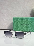 Gucci glasses with silver-tone frame and dark gray gradient lenses.