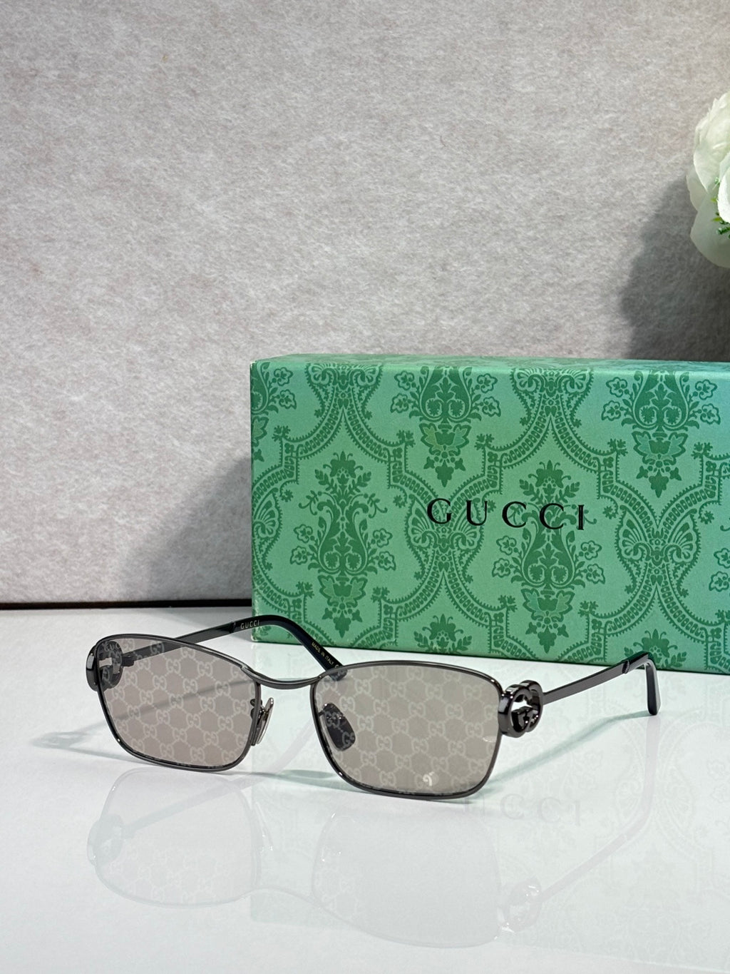 Gucci glasses with dark frame and dark gray gradient lenses.