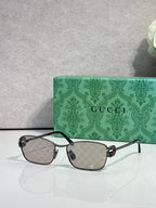Gucci glasses with dark frame and dark gray gradient lenses.