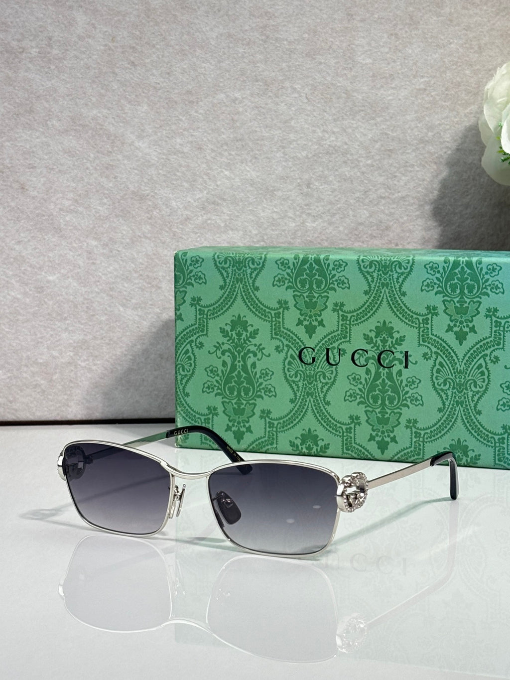 Gucci glasses with silver-tone frame and dark gray gradient lenses.