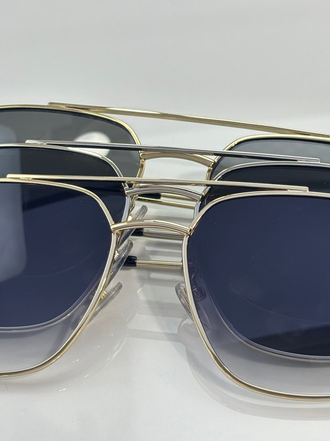 Sunglasses bridge and temples close-up with gold frames and dark lenses