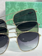 Sunglasses with gold frames and dark lenses, angled side view