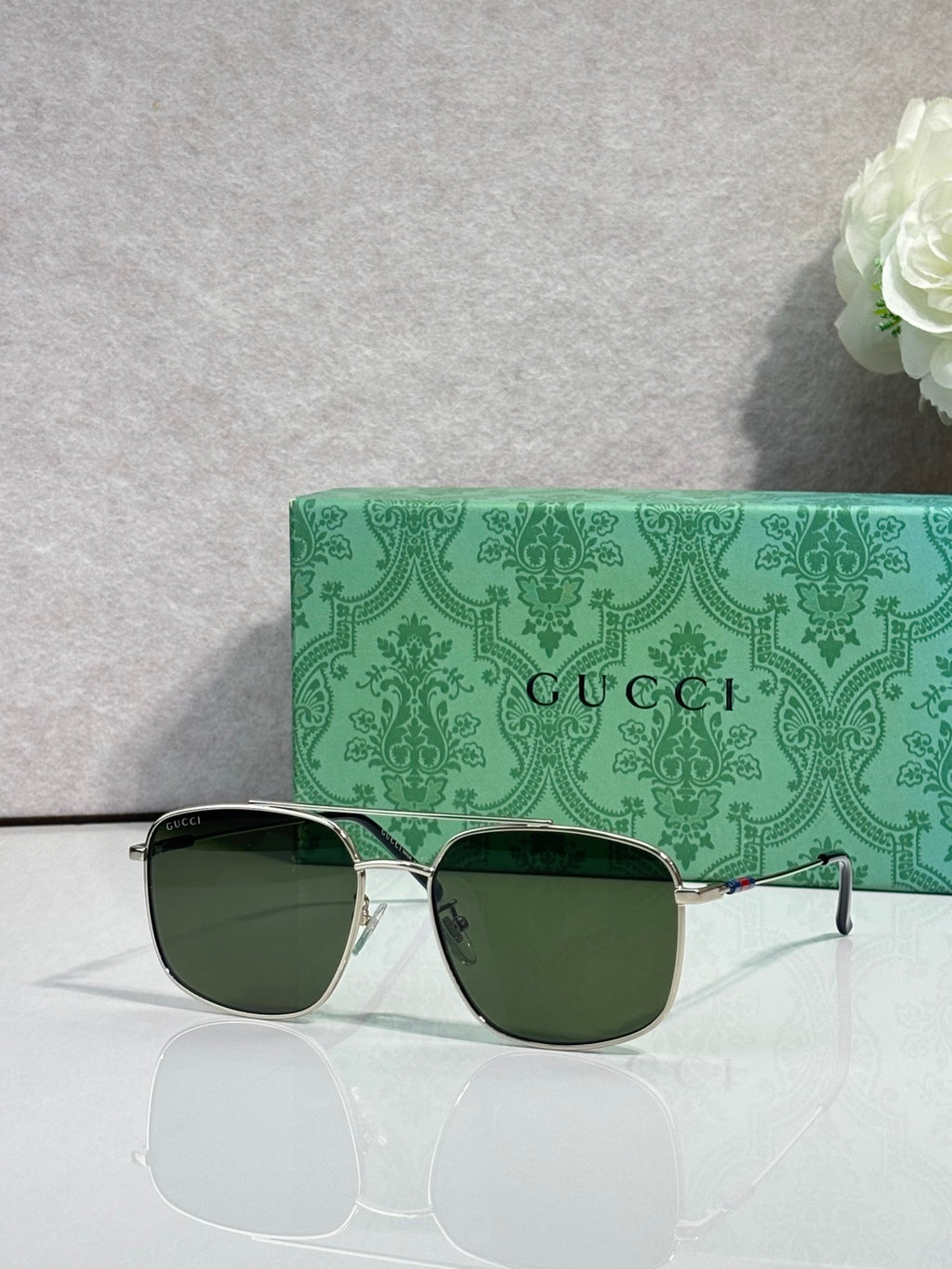 Sunglasses with gold frame, dark lenses, and multicolor temple stripe detail
