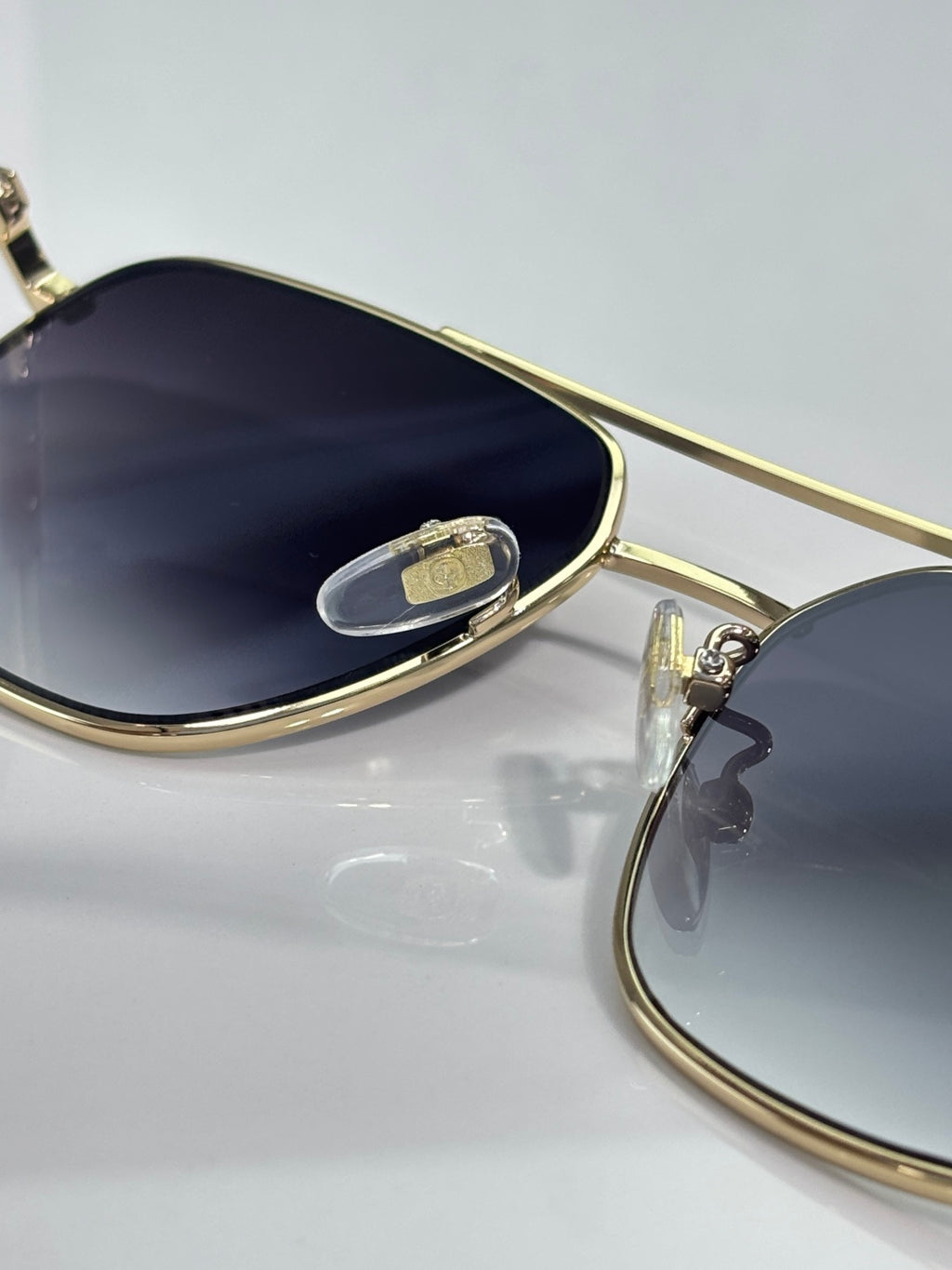 Sunglasses lens close-up with gold frame and dark tinted glass
