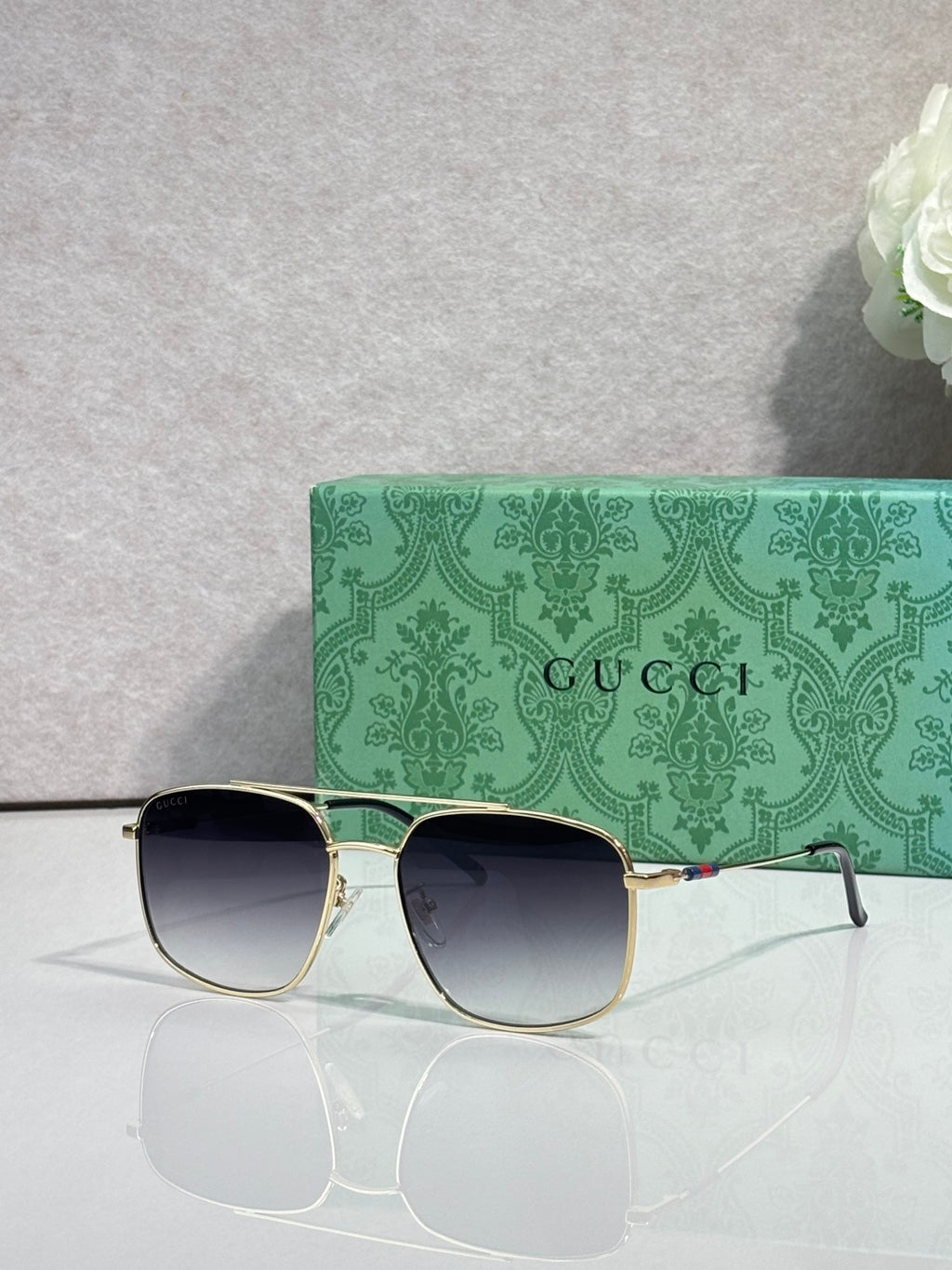 Sunglasses with gold frame and blue-to-dark gradient lenses