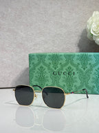 Gold-tone square sunglasses with dark lenses and green temples