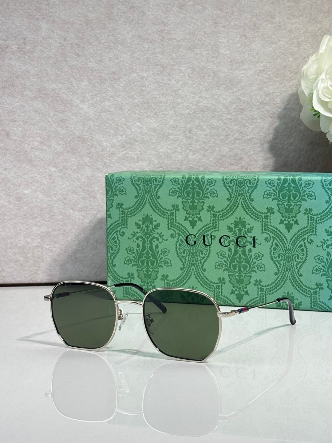 Gold-tone square sunglasses with dark green-tinted lenses and green temples