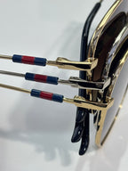 Gold-tone sunglasses temples with red and blue beaded accents near hinge