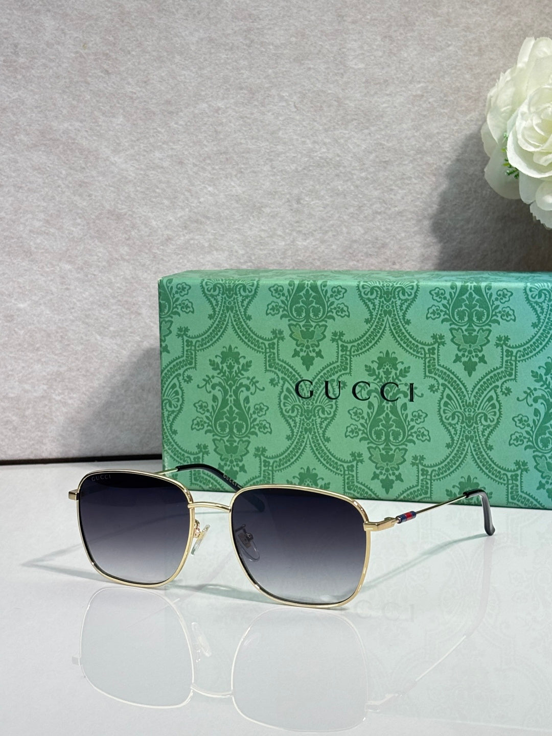 Gucci square sunglasses with gold frame and dark lenses, thin metal side arms