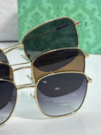 Gucci sunglasses pair stack with gold frames and dark lenses, temple details visible