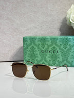 Gucci square sunglasses with gold frame and dark brown lenses, logo on arms