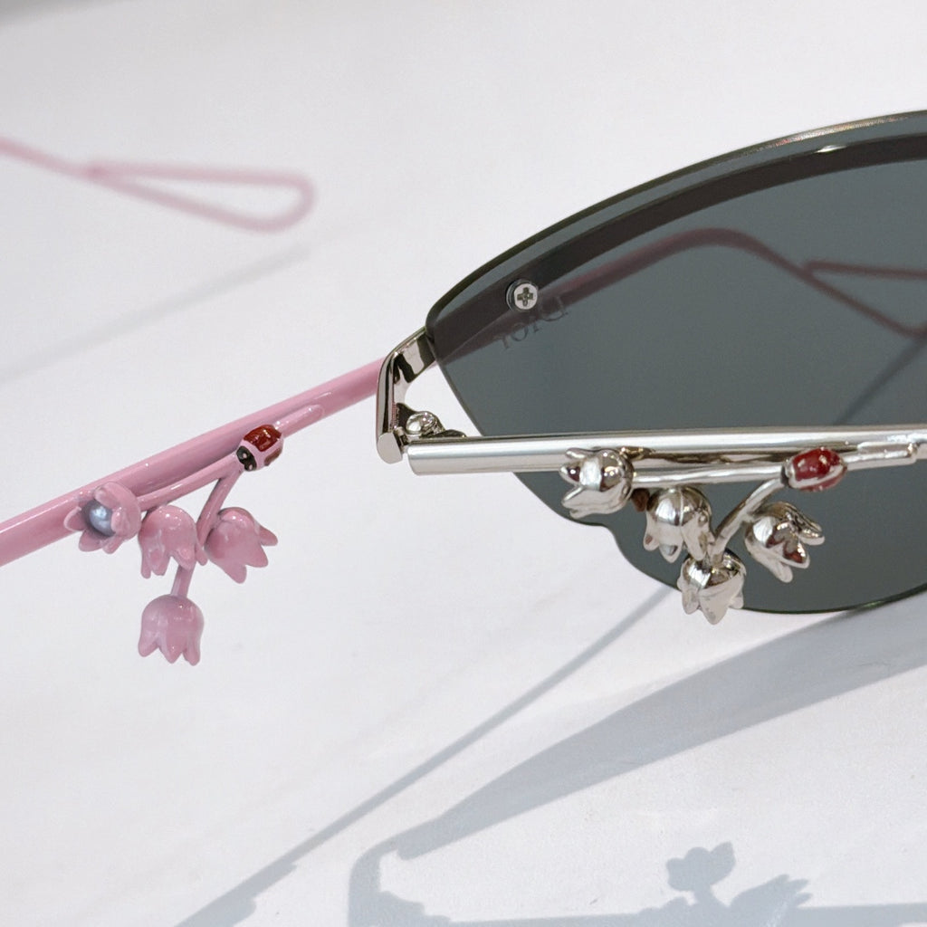 Pink Dior sunglasses with close-up side arm and dangling floral charm