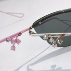 Pink Dior sunglasses with close-up side arm and dangling floral charm