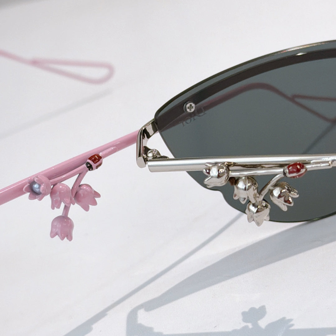 Pink Dior sunglasses with close-up side arm and dangling floral charm