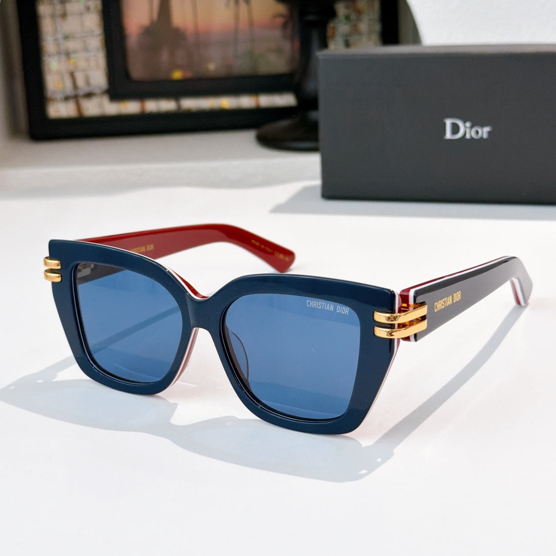 Dior sunglasses with dark frames, red temple accents, blue lenses, gold hinges.