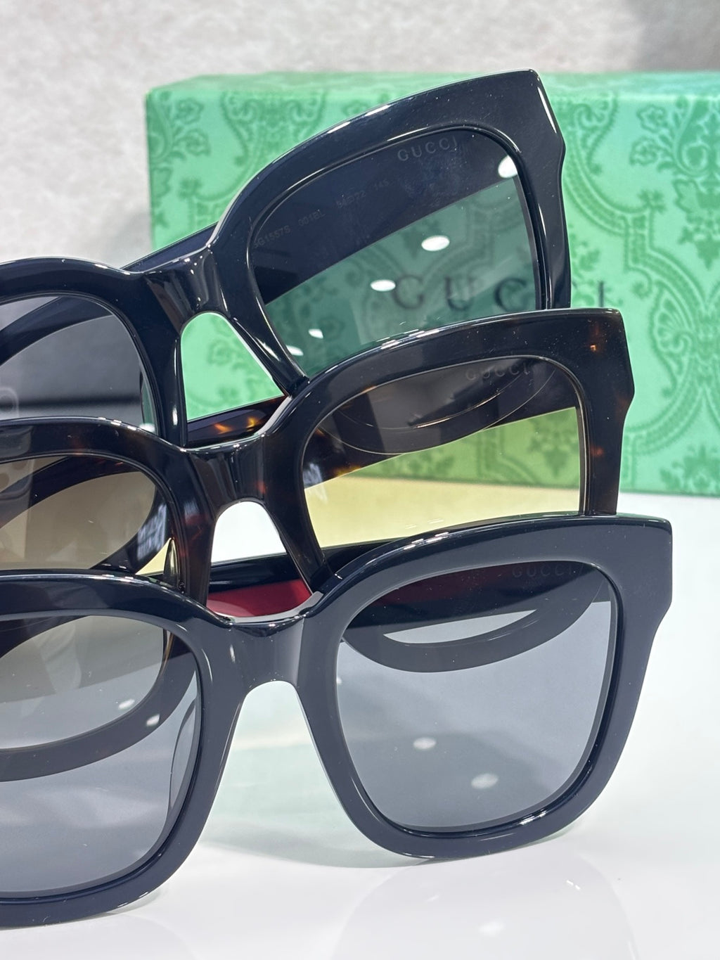 Gucci square sunglasses with dark lenses, shown in close-up