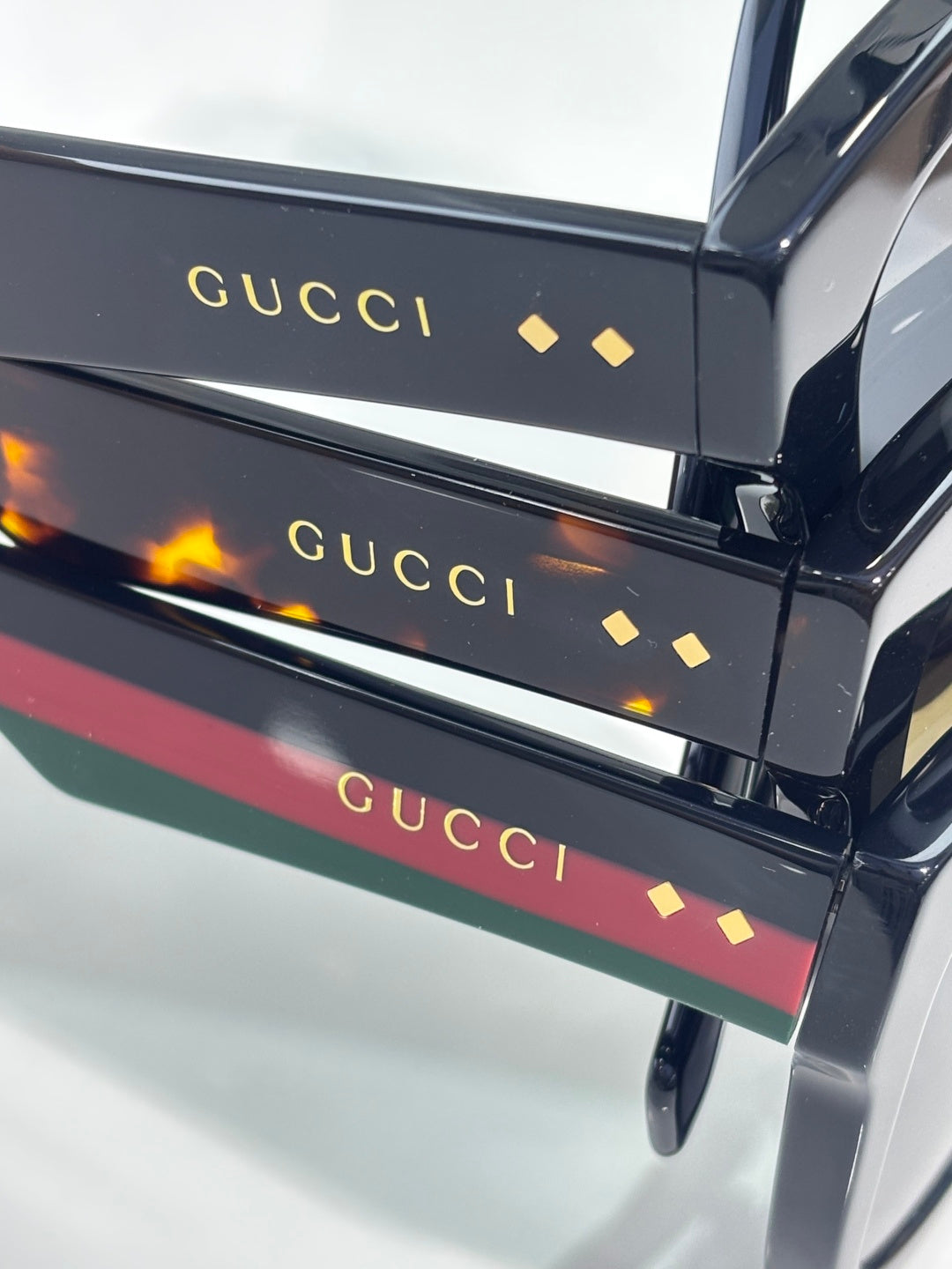 Gucci sunglasses temple arms with colored stripes and gold “Gucci” logo