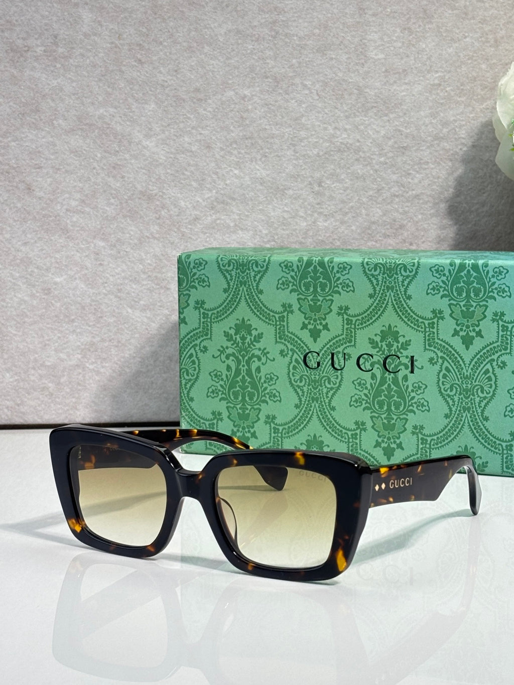 Gucci sunglasses with dark frames and beige-tinted lenses