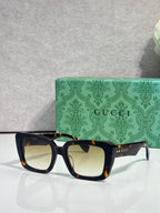 Gucci sunglasses with dark frames and beige-tinted lenses
