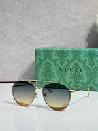 Sunglasses with gradient dark lenses, gold-tone frame, slim metal temples