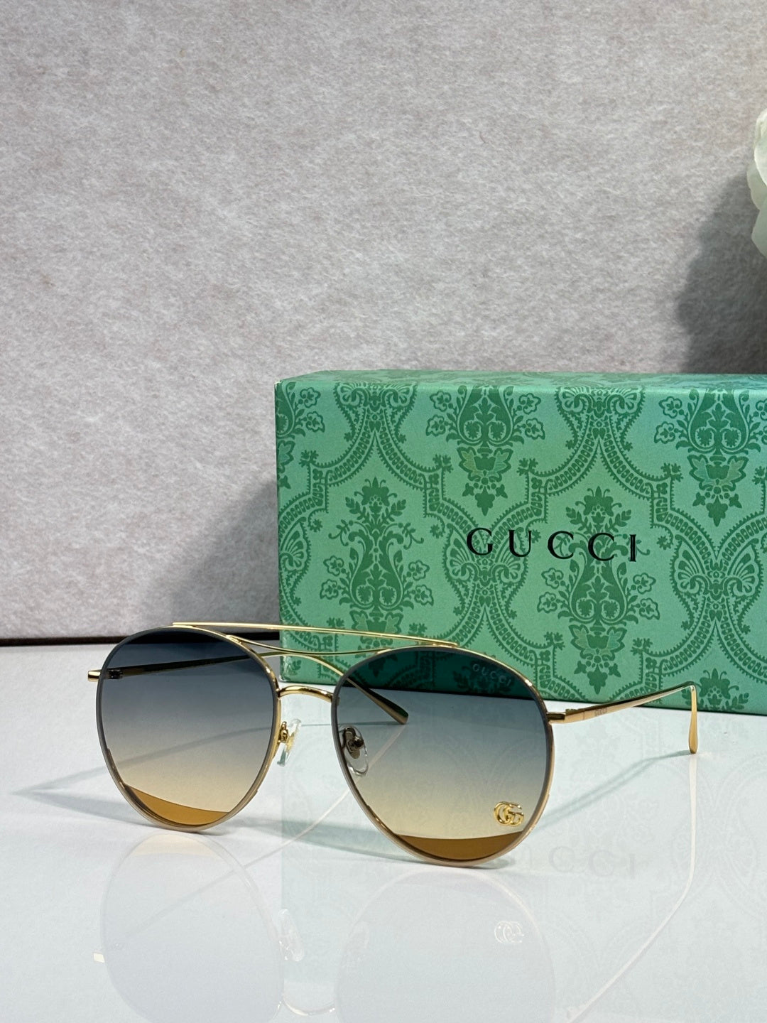 Sunglasses with gradient dark lenses, gold-tone frame, slim metal temples