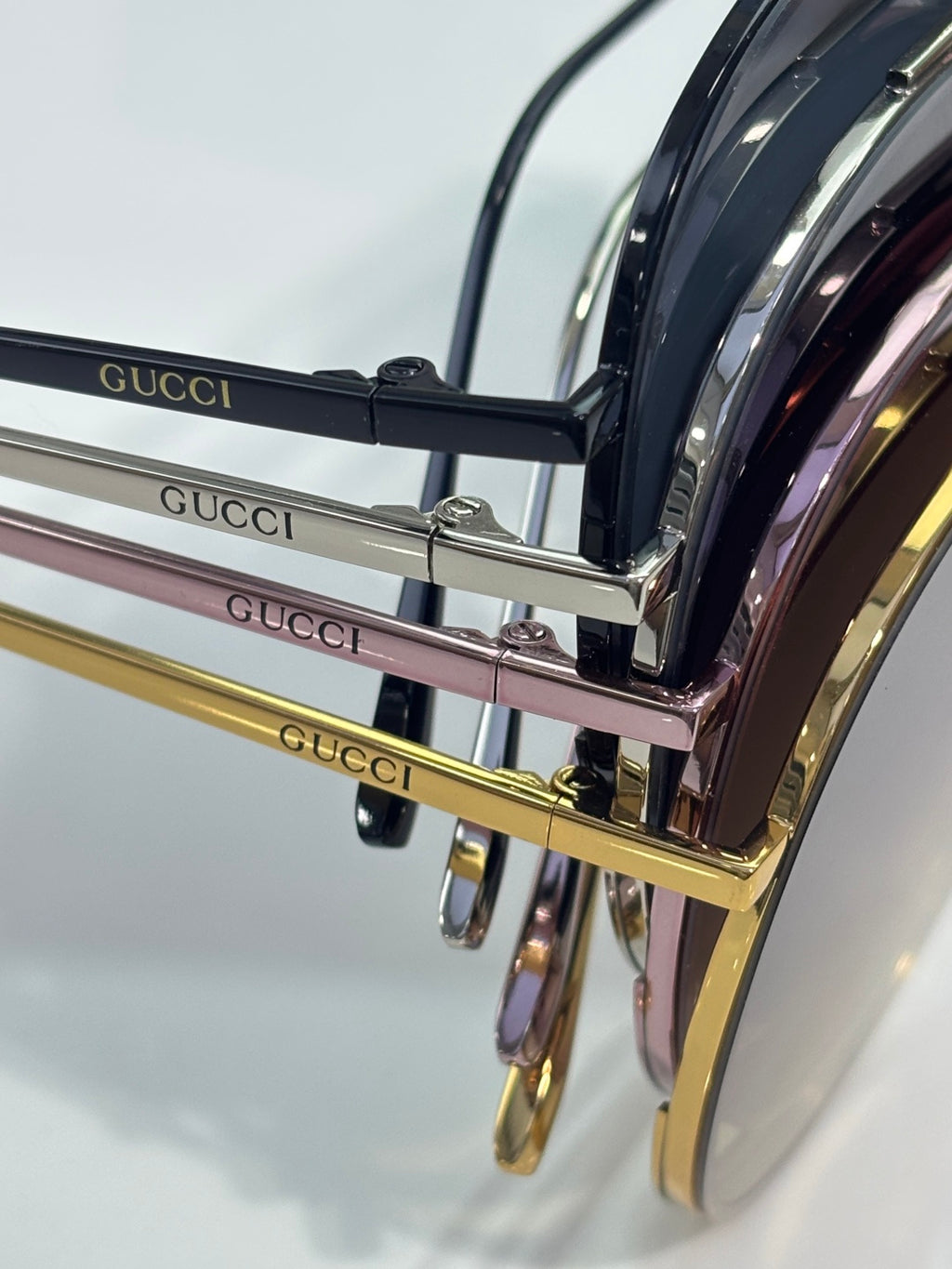 Stacked sunglasses with black lenses and mixed gold-tone and pink frames