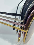 Stacked sunglasses with black lenses and mixed gold-tone and pink frames
