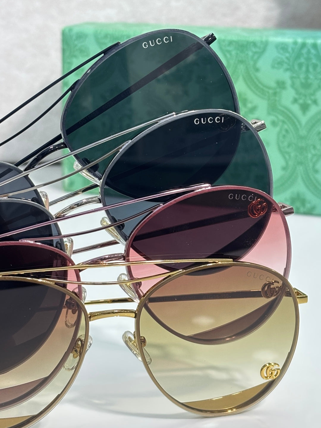 Assorted sunglasses stack with dark, pink, and gold-tinted round lenses