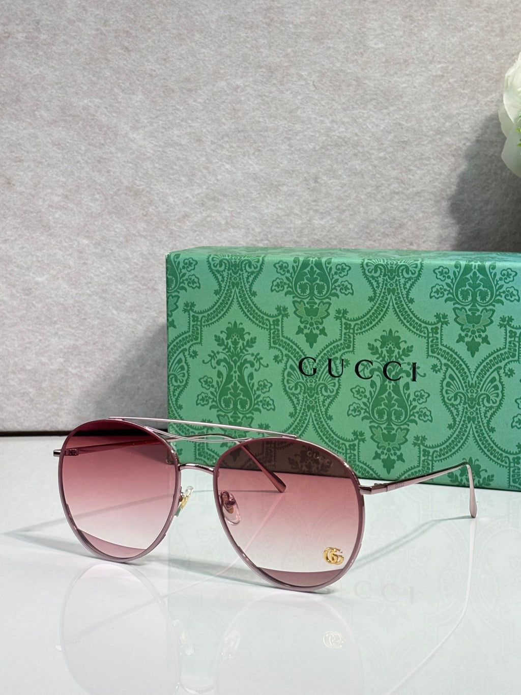 Sunglasses with pink mirrored round lenses, rose-tone frame, gold-tone arms