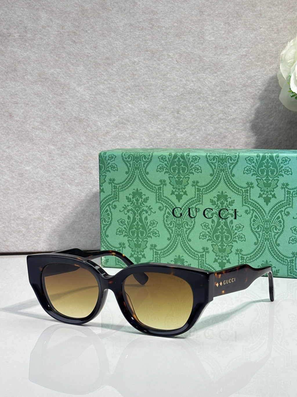 Gucci sunglasses with dark navy frame and brown-tinted lenses, rounded rectangular shape