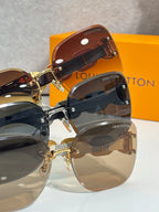 Sunglasses close-up on display: overlapping tinted lenses and gold chain-link temples.