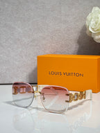 Sunglasses with rose-gold frame and tinted gradient lenses; gold logo temple details.