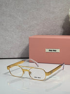 Gold eyeglasses with clear lenses and light pink temple arms, metal frame with logo plate