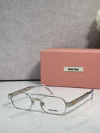 Silver eyeglasses with clear lenses and light pink temple arms, metal frame with logo plate