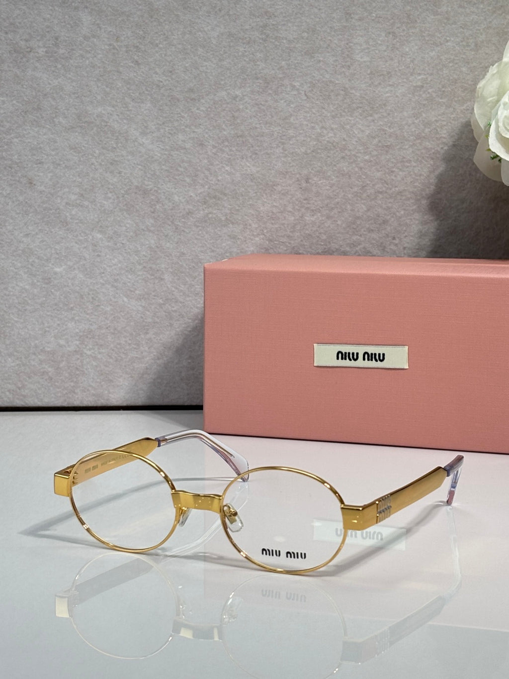 Round metal eyeglass frames with clear lenses, mixed gold and silver tones, Miu Miu logo.