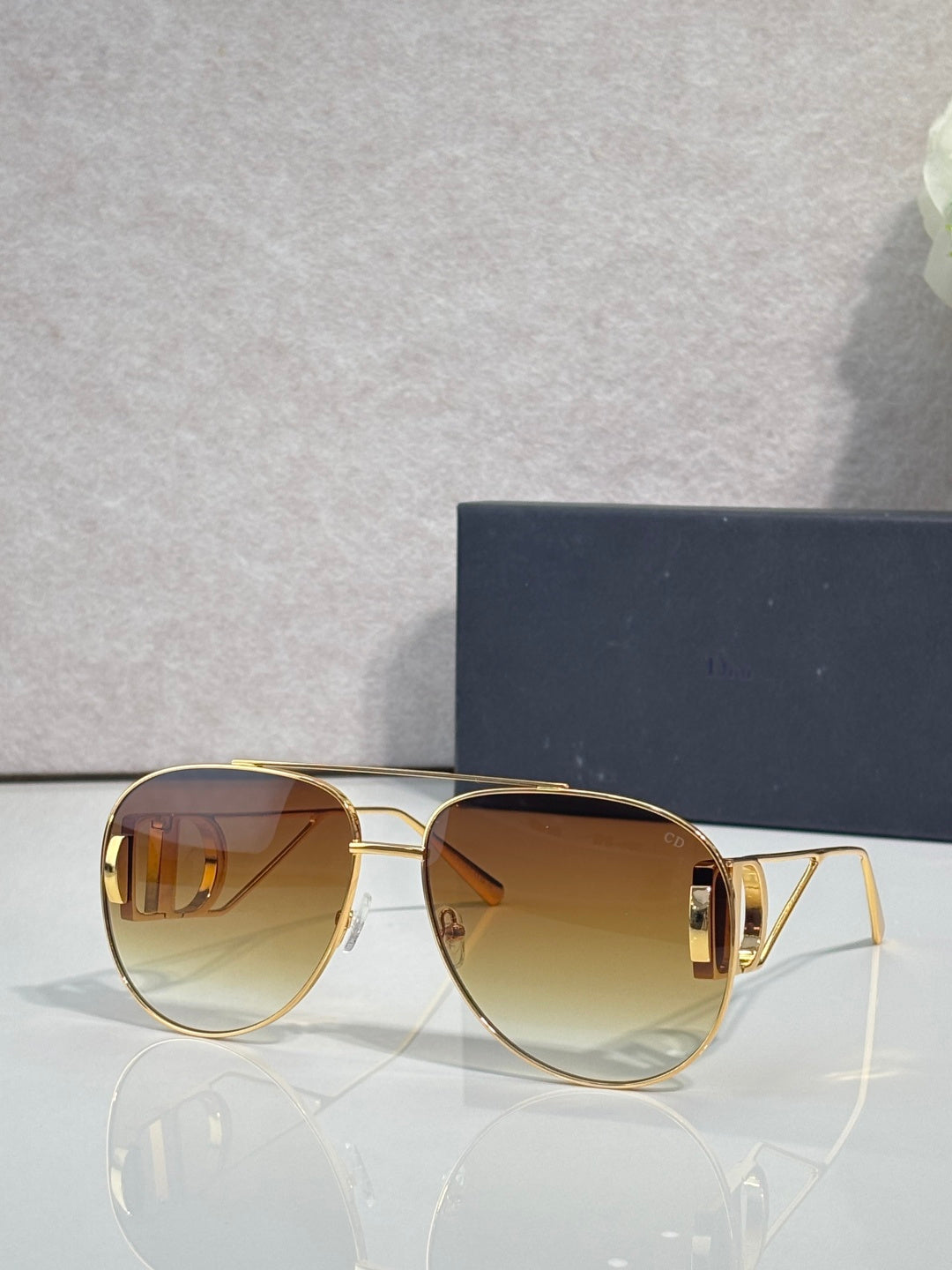 Dior sunglasses with warm brown tinted lenses and gold-tone metal frames