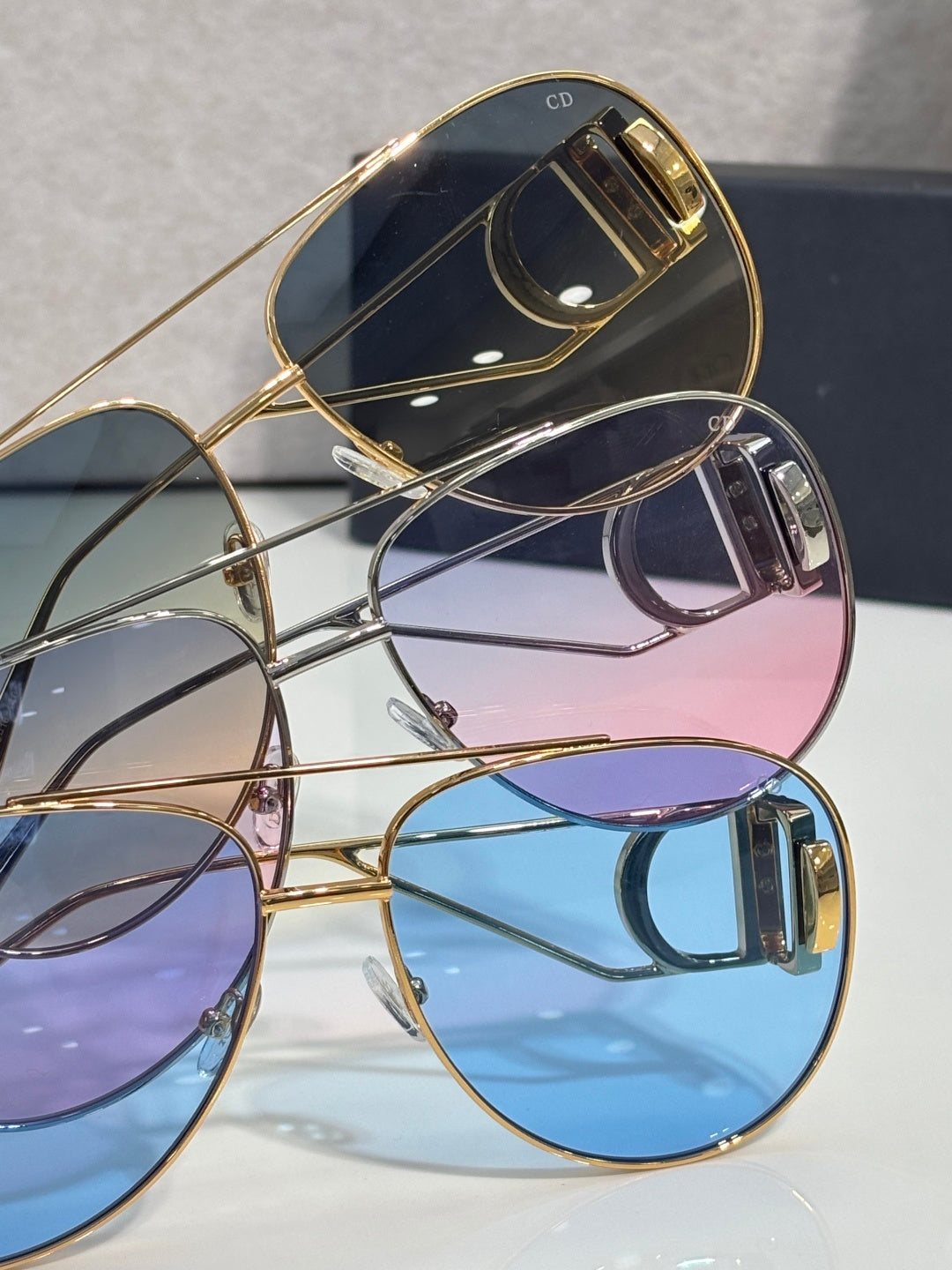 Dior sunglasses set with blue, purple, and dark tinted lenses, gold-tone frames