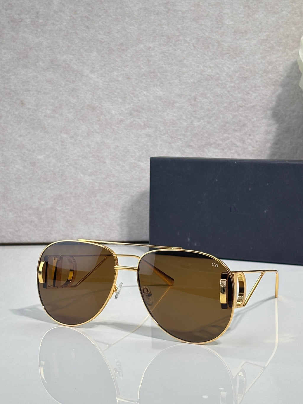 Dior sunglasses with amber tinted lenses and gold-tone metal frames