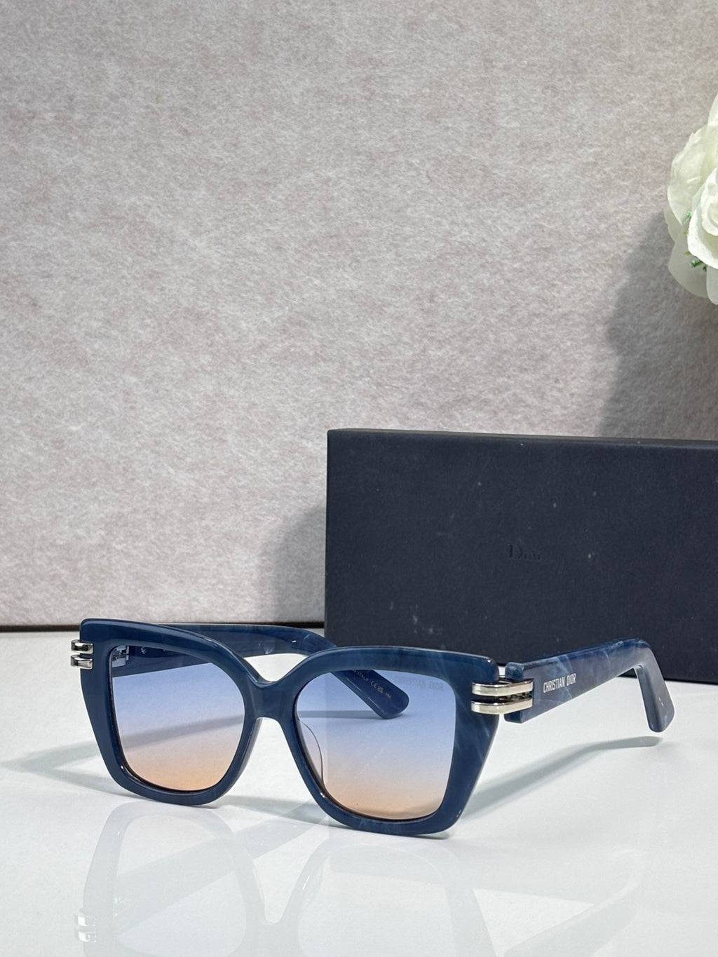 Dior eyeglasses with dark blue frames and gold bar details, clear-tinted lenses