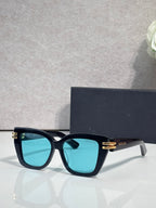 Dior eyeglasses with dark teal frames and gold bar details, turquoise tinted lenses