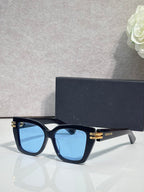 Dior eyeglasses with dark blue frames and gold bar details, light blue tinted lenses