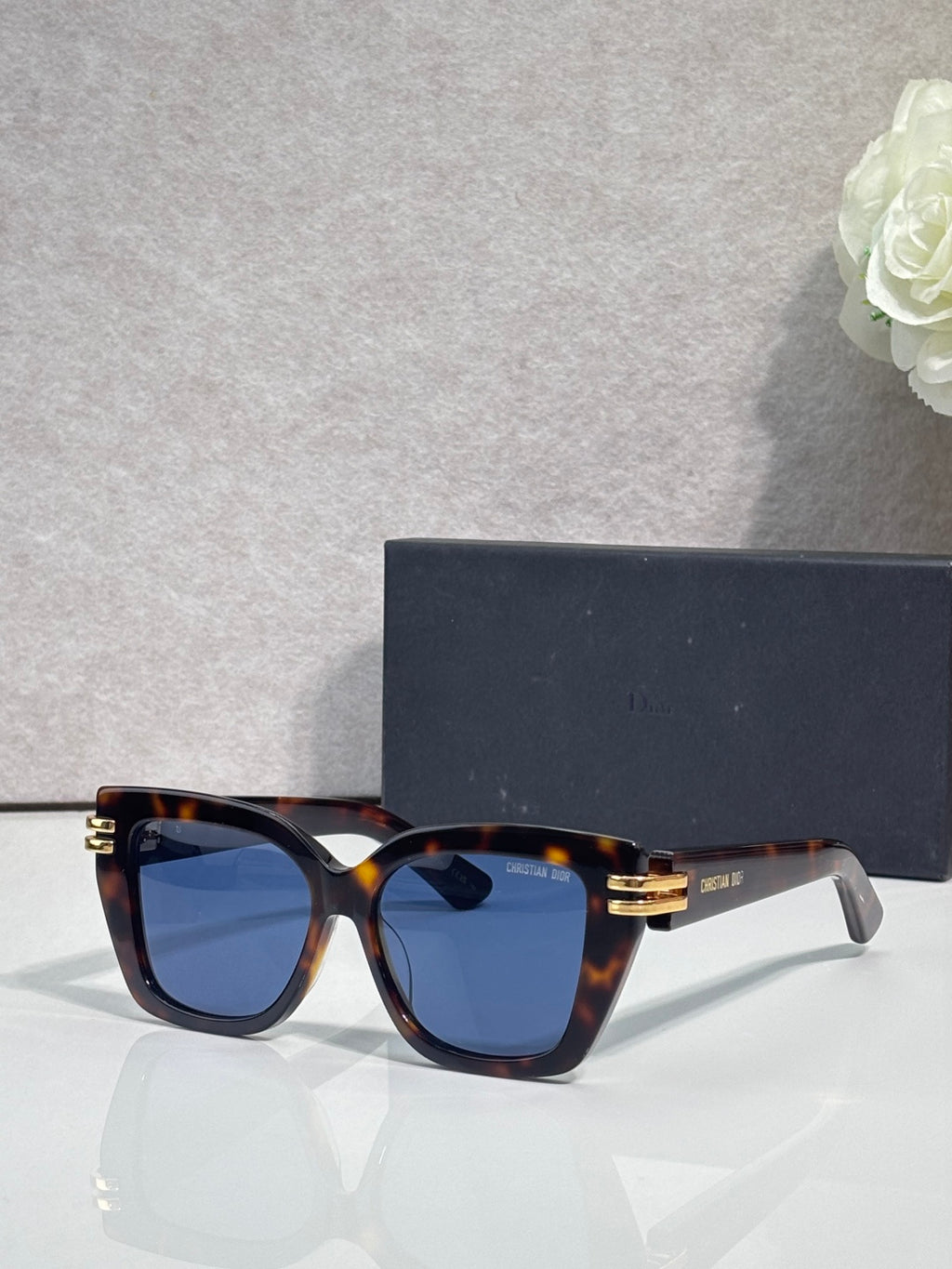 Dior eyeglasses with tortoiseshell frames and gold bar details, dark blue tinted lenses