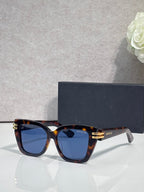 Dior eyeglasses with tortoiseshell frames and gold bar details, dark blue tinted lenses