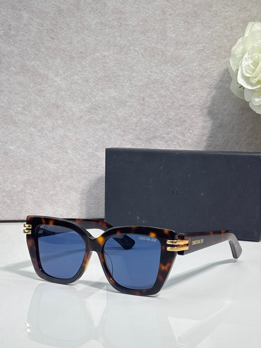 Dior eyeglasses with tortoiseshell frames and gold bar details, dark blue tinted lenses