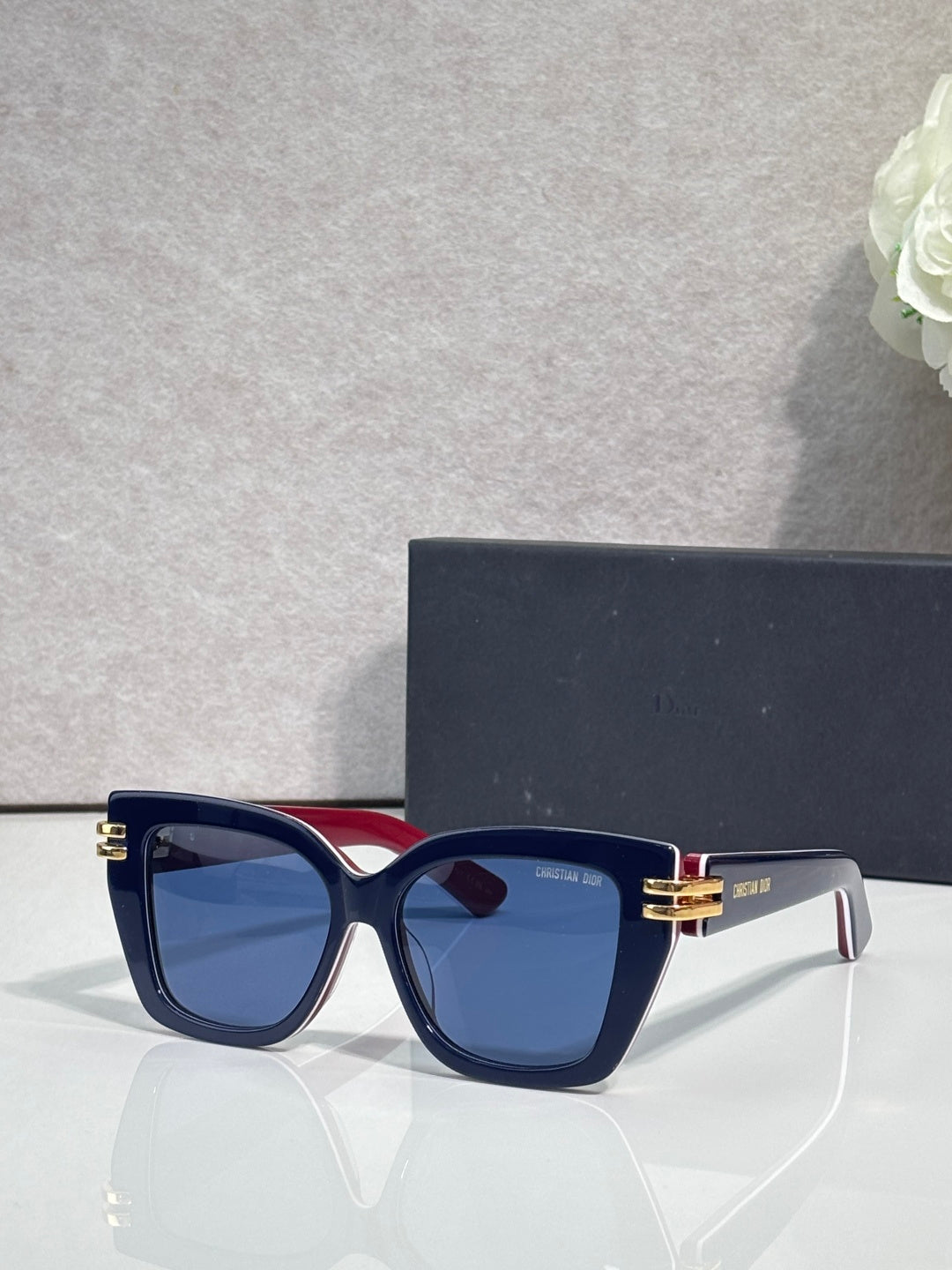 Dior eyeglasses with navy frames, gold bar details, and blue tinted lenses