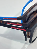 Prada sunglasses side view with dark tortoiseshell temples, blue accents, and logo bar