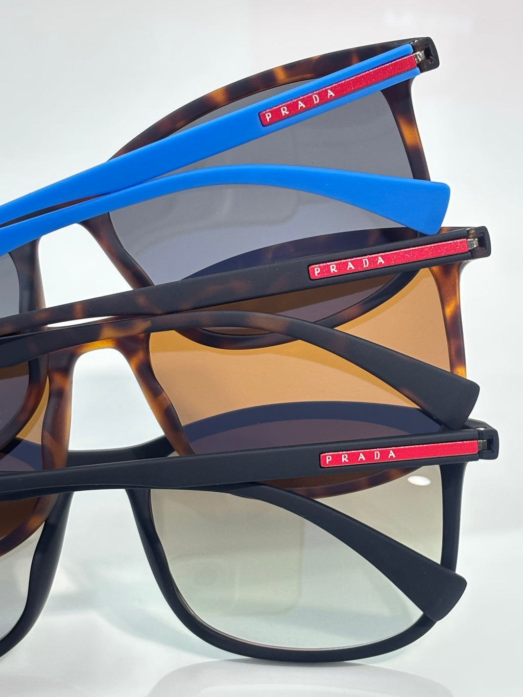 Prada sunglasses angled view with tortoiseshell frames and blue temple stripes