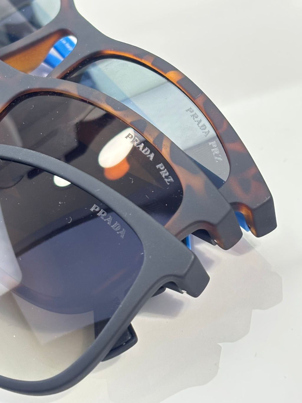 Prada sunglasses close-up of tortoiseshell temples and dark lenses with printed logos