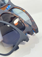 Prada sunglasses close-up of tortoiseshell temples and dark lenses with printed logos