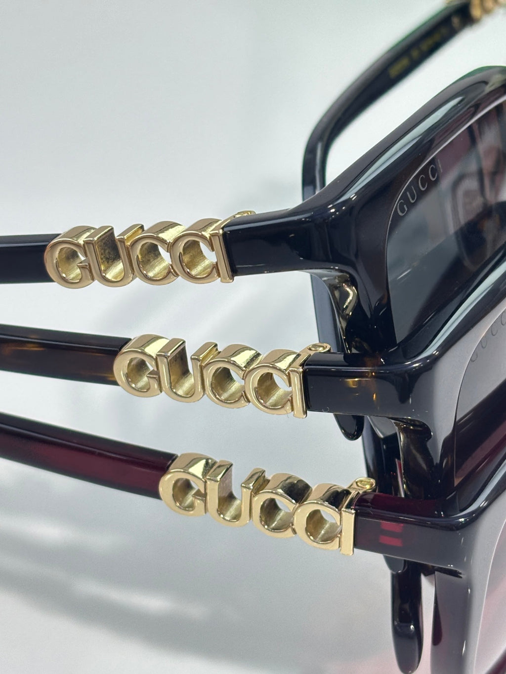 Black sunglasses with gold-toned decorative temple hardware and tinted lenses
